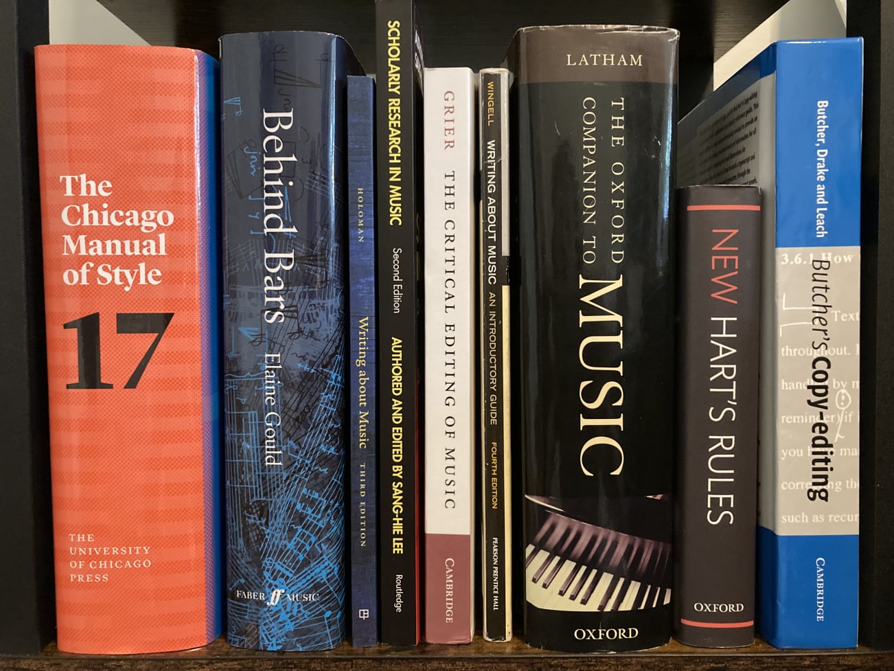 Photo of bookshelf showing books for editors and writing about music.